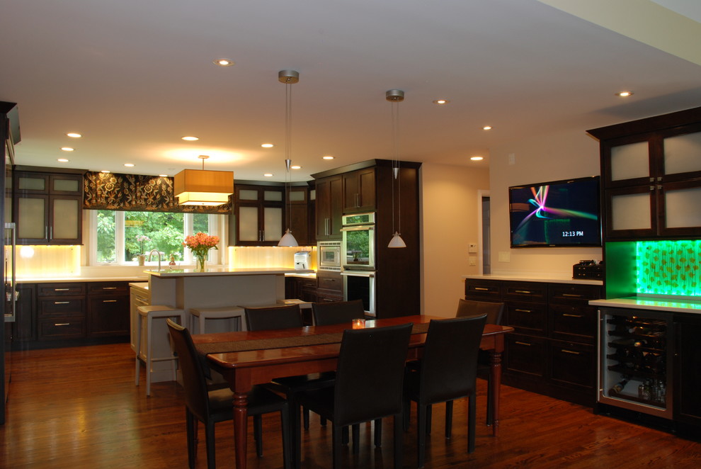 Photo of a large asian u-shaped eat-in kitchen in Chicago with flat-panel cabinets, dark wood cabinets, quartz benchtops, stainless steel appliances, medium hardwood floors and with island.