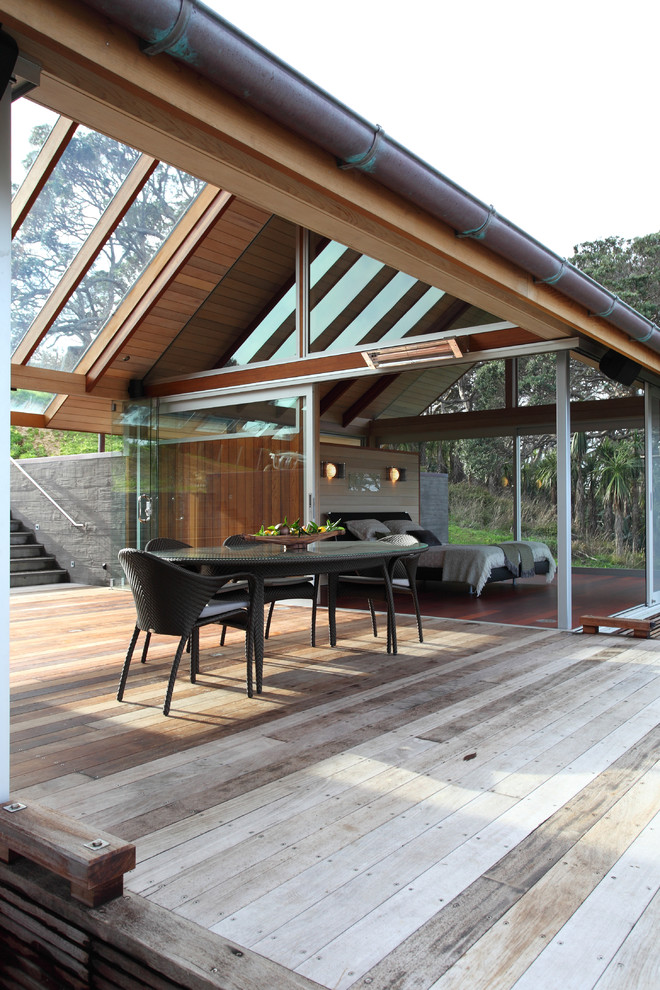 Photo of a contemporary deck in Other with a roof extension.
