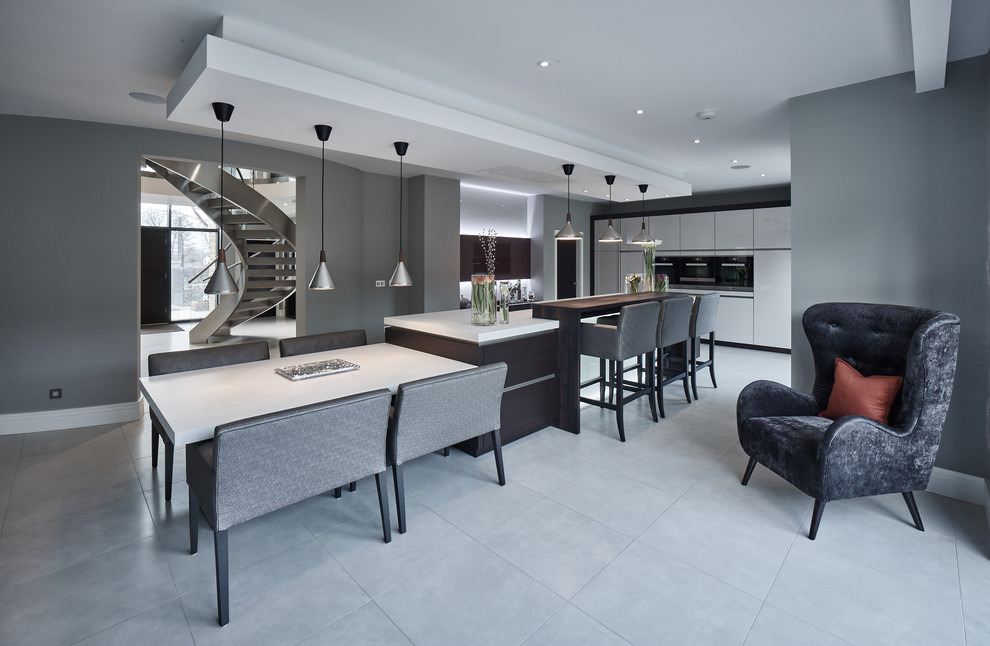 Inspiration for an expansive contemporary single-wall open plan kitchen in Other with flat-panel cabinets, solid surface benchtops, stainless steel appliances, porcelain floors, with island, white cabinets, grey floor and white benchtop.