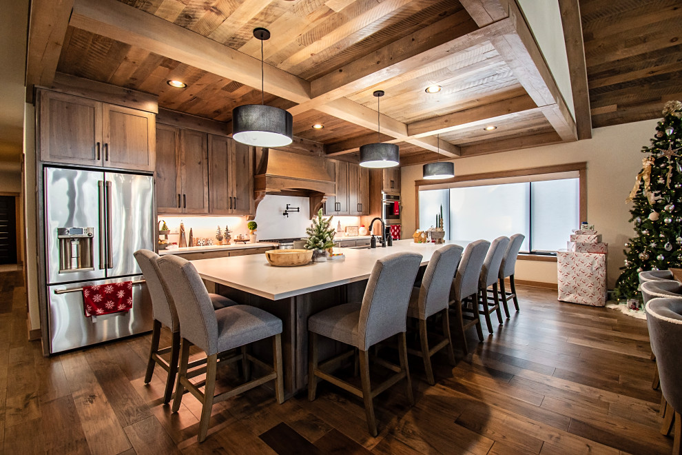 Example of a large mountain style single-wall medium tone wood floor, multicolored floor and coffered ceiling eat-in kitchen design with a farmhouse sink, flat-panel cabinets, light wood cabinets, quartzite countertops, multicolored backsplash, granite backsplash, stainless steel appliances, an island and multicolored countertops