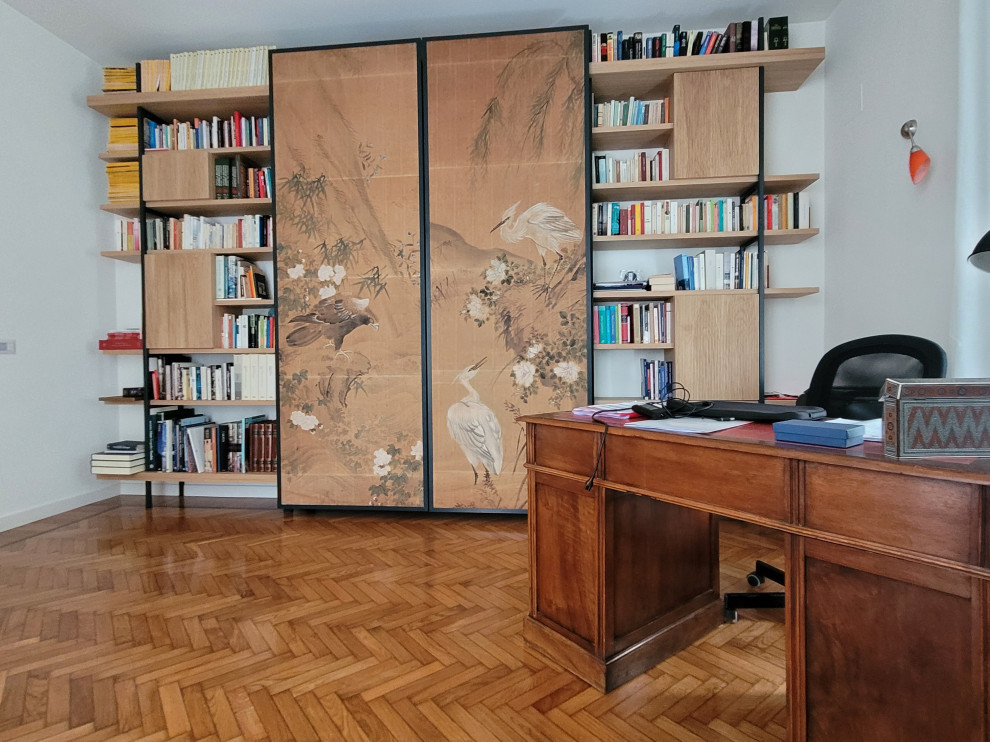 Mid-sized midcentury home office in Rome with a library and light hardwood floors.