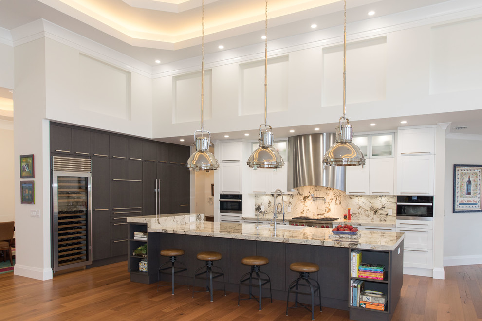 Design ideas for a large eclectic l-shaped open plan kitchen in Other with a farmhouse sink, shaker cabinets, white cabinets, marble benchtops, beige splashback, stone slab splashback, panelled appliances, medium hardwood floors, with island, brown floor and beige benchtop.