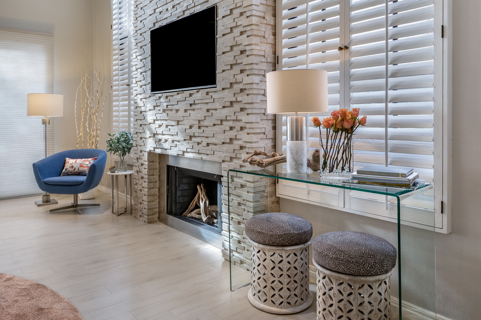 This is an example of a large contemporary family room in Phoenix with grey walls, porcelain floors, a standard fireplace, a stone fireplace surround and beige floor.