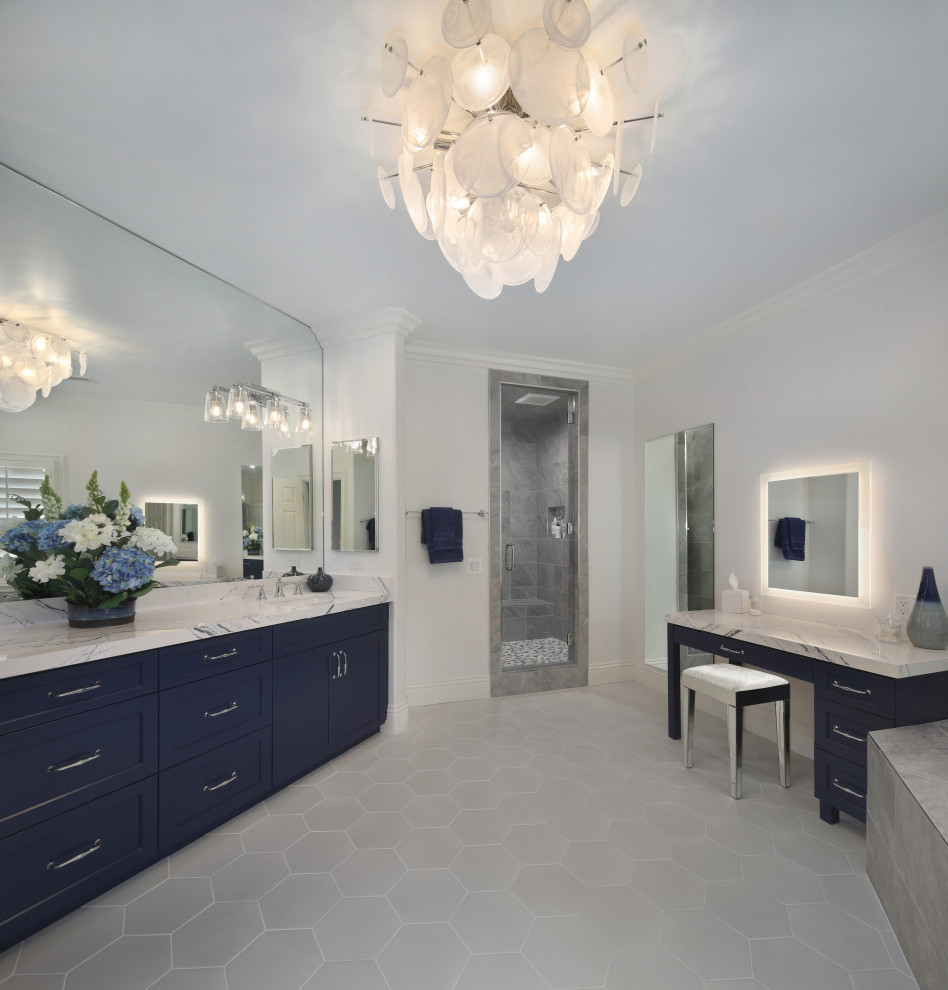 Photo of a large traditional ensuite bathroom in Orange County with shaker cabinets, blue cabinets, a built-in bath, a double shower, a one-piece toilet, white tiles, porcelain tiles, white walls, porcelain flooring, a submerged sink, engineered stone worktops, white floors, a hinged door, blue worktops, a shower bench, double sinks and a built in vanity unit.