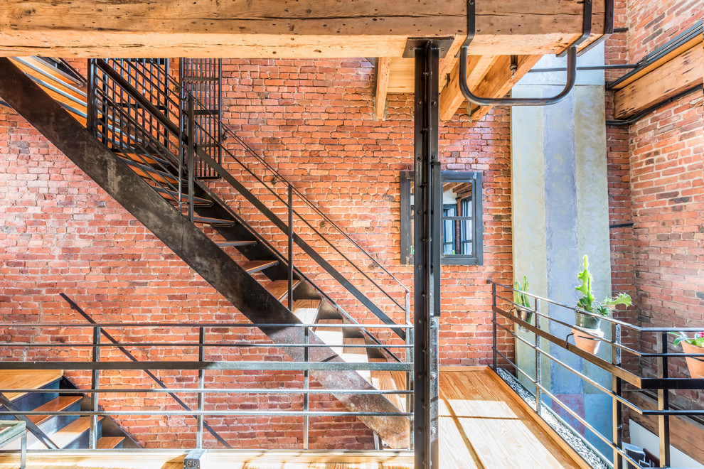 This is an example of an expansive industrial wood staircase in New York with open risers.