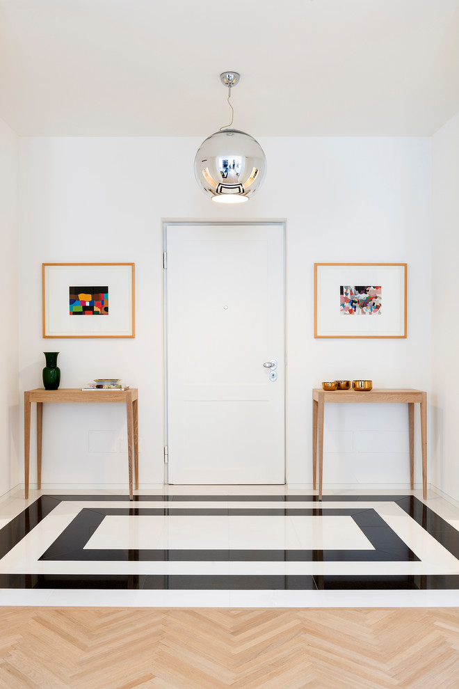 Photo of a contemporary foyer in Other with white walls, a single front door, a white front door and multi-coloured floor.