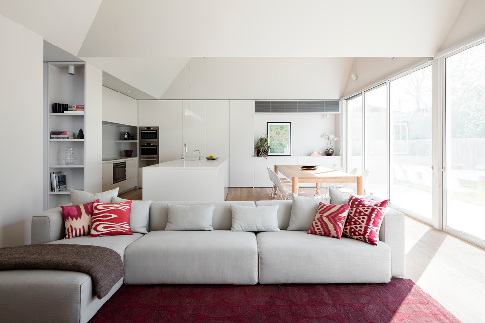 Inspiration for a mid-sized contemporary open concept living room in Melbourne with grey walls, light hardwood floors, no fireplace and a wall-mounted tv.