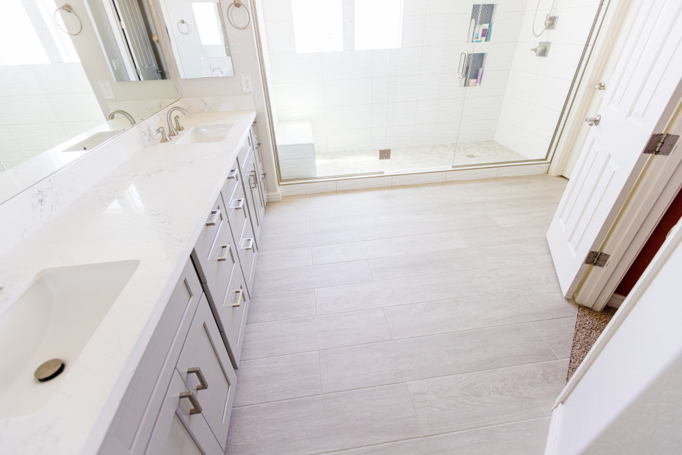 Example of a large transitional master white tile and cement tile wood-look tile floor, gray floor and double-sink bathroom design in Phoenix with shaker cabinets, gray cabinets, white walls, an undermount sink, quartzite countertops, a hinged shower door, white countertops and a built-in vanity