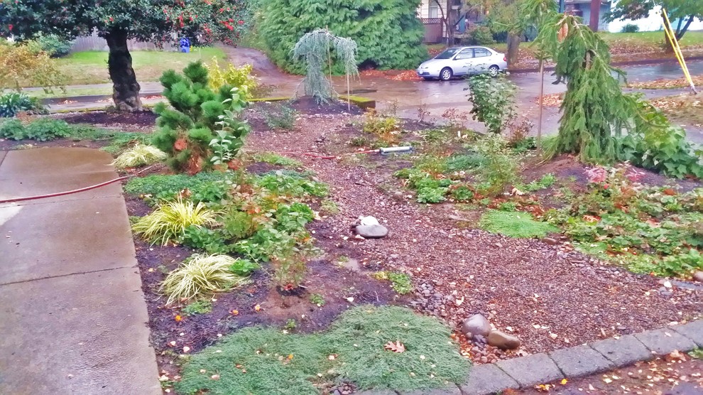 This is an example of a mid-sized arts and crafts xeriscape for winter in Portland with a garden path and natural stone pavers.