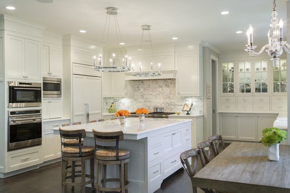 Photo of a transitional eat-in kitchen in Minneapolis with shaker cabinets, white cabinets, white splashback, stainless steel appliances, dark hardwood floors and with island.