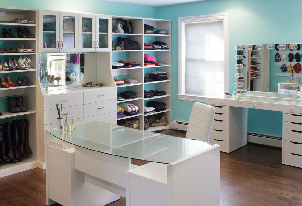 Photo of a large traditional women's dressing room in New York with flat-panel cabinets, white cabinets and medium hardwood floors.