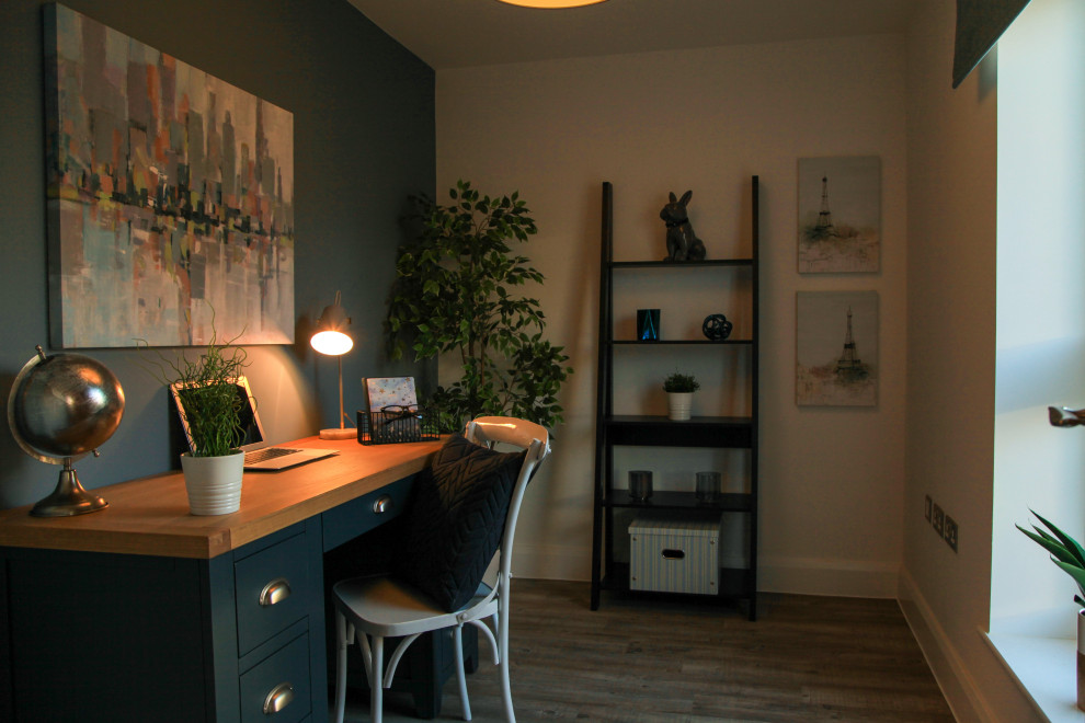 Immagine di un piccolo ufficio minimalista con pareti blu, pavimento in legno massello medio, scrivania autoportante e pavimento grigio
