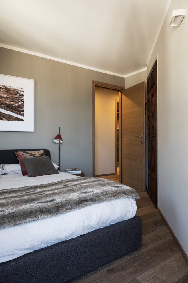 Ejemplo de dormitorio rústico pequeño con paredes beige y suelo de madera clara