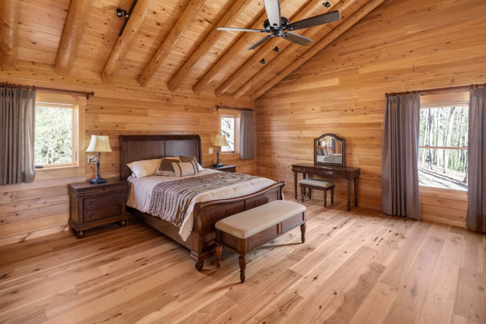 Foto di una grande camera matrimoniale stile rurale con parquet chiaro, soffitto in legno e pareti in legno