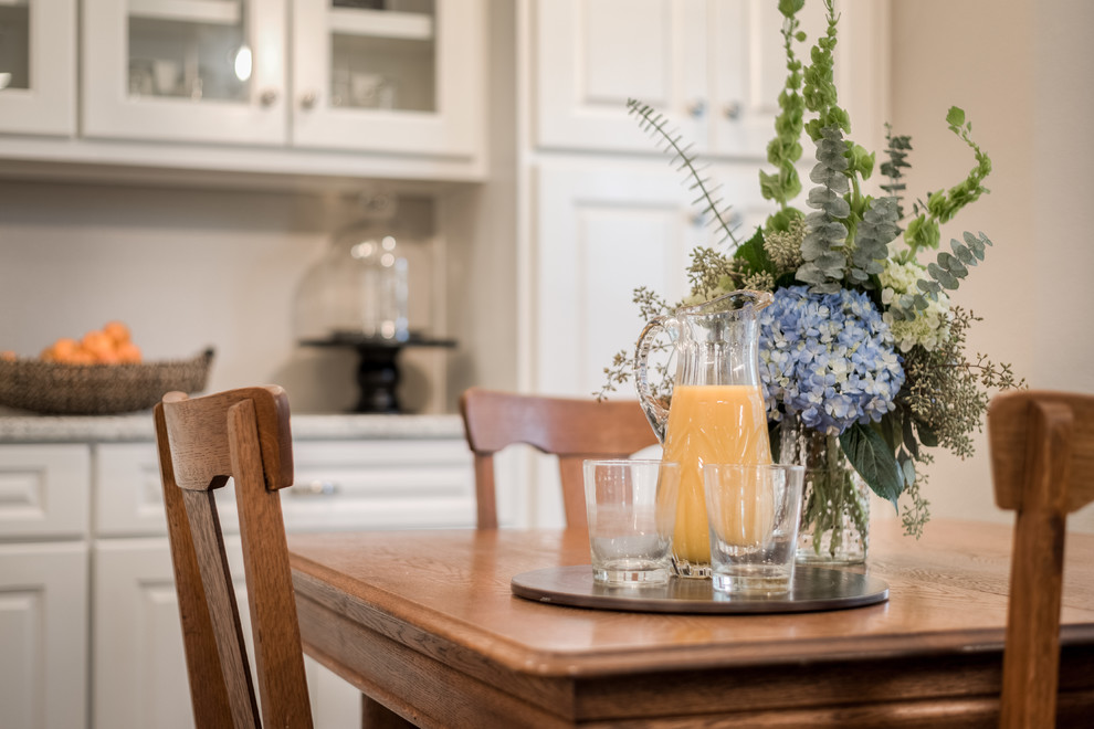 Enclosed kitchen - mid-sized transitional galley medium tone wood floor enclosed kitchen idea in Dallas with an undermount sink, raised-panel cabinets, white cabinets, granite countertops, white backsplash, subway tile backsplash, stainless steel appliances and a peninsula