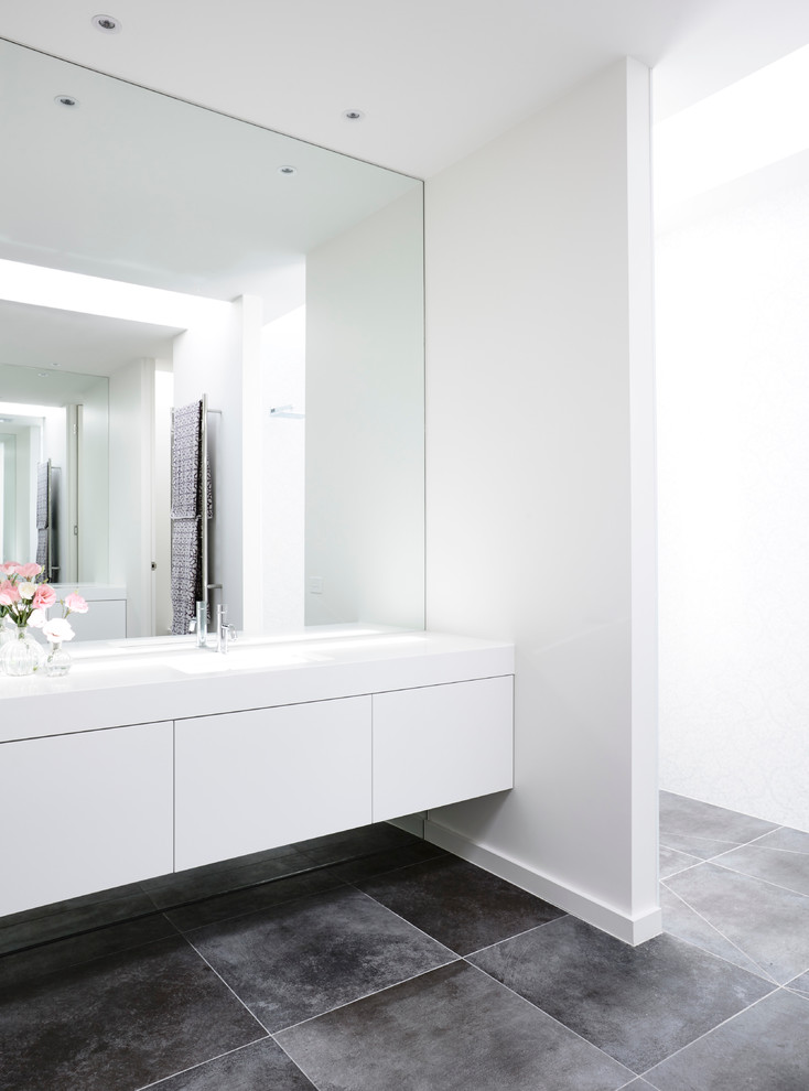 This is an example of a contemporary master bathroom in Melbourne with flat-panel cabinets, white cabinets, a double shower, gray tile, ceramic tile, white walls, ceramic floors, an integrated sink and marble benchtops.