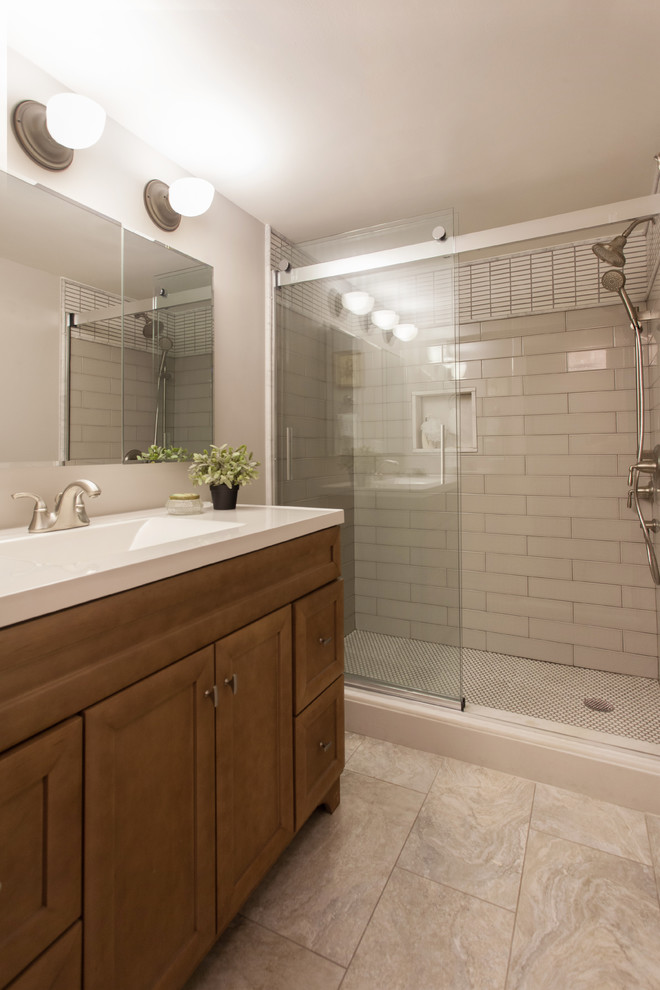 Design ideas for a small transitional 3/4 bathroom in Other with recessed-panel cabinets, medium wood cabinets, an alcove shower, a two-piece toilet, white tile, ceramic tile, beige walls, dark hardwood floors, a wall-mount sink, solid surface benchtops, beige floor and a shower curtain.