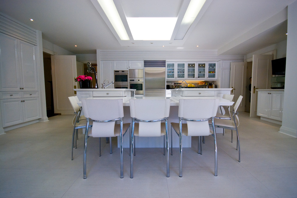 Large transitional u-shaped marble floor eat-in kitchen photo in Toronto with a single-bowl sink, raised-panel cabinets, white cabinets, solid surface countertops, stainless steel appliances and a peninsula