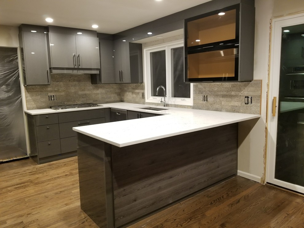 Inspiration for a large modern u-shaped eat-in kitchen in Detroit with an undermount sink, glass-front cabinets, grey cabinets, quartz benchtops, multi-coloured splashback, stone tile splashback, stainless steel appliances, dark hardwood floors, a peninsula, brown floor and white benchtop.