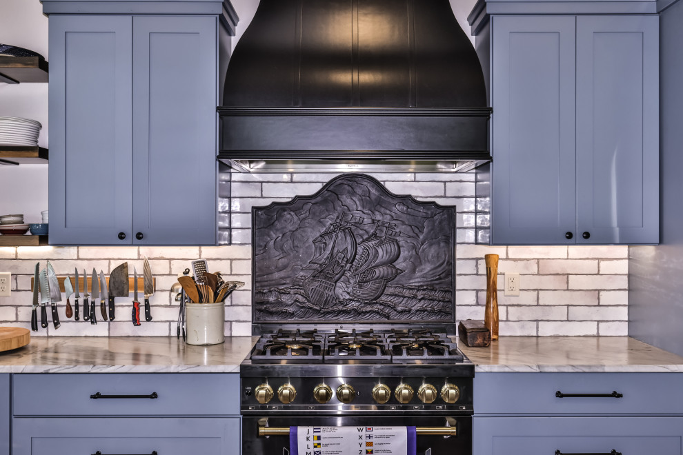 Mid-sized mountain style u-shaped dark wood floor, brown floor and vaulted ceiling open concept kitchen photo with an undermount sink, shaker cabinets, blue cabinets, quartzite countertops, white backsplash, ceramic backsplash, black appliances, an island and white countertops