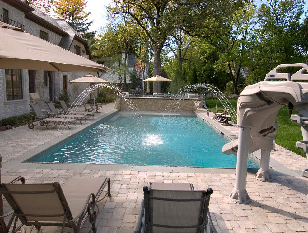 Photo of a mid-sized traditional backyard rectangular lap pool in Chicago with concrete pavers.