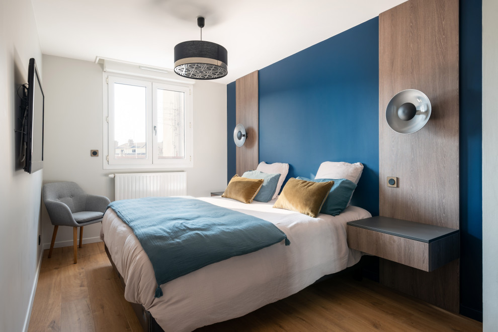 Photo of a mid-sized scandinavian bedroom in Saint-Etienne with blue walls, light hardwood floors and no fireplace.