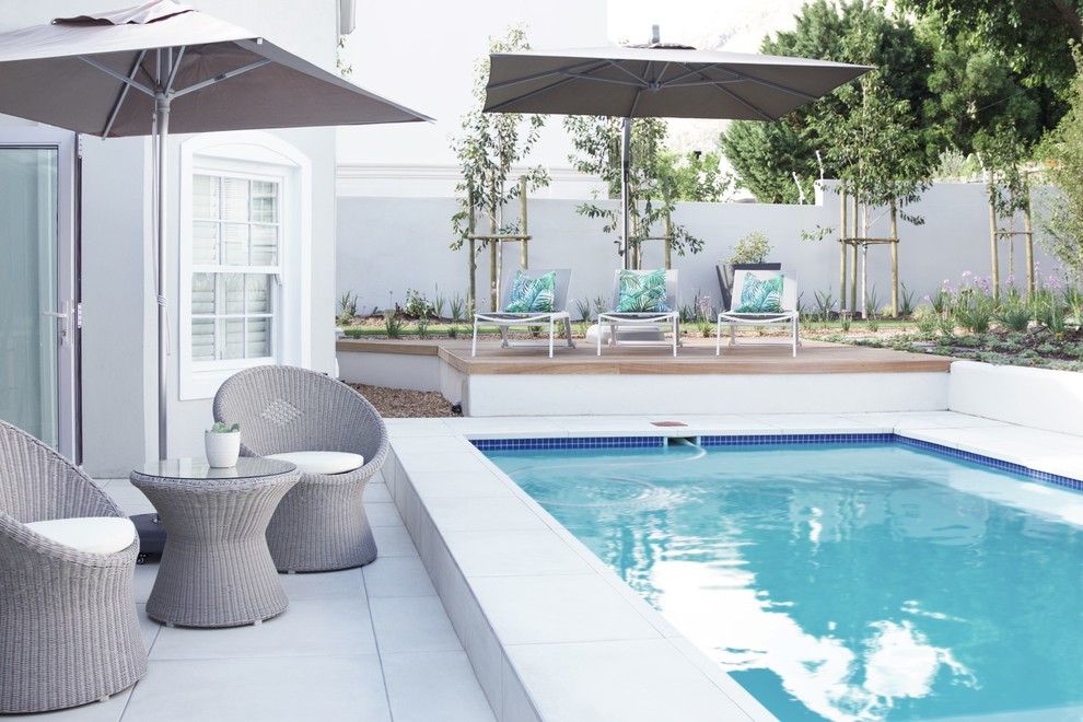 Inspiration for a large contemporary backyard rectangular aboveground pool in Other with tile.