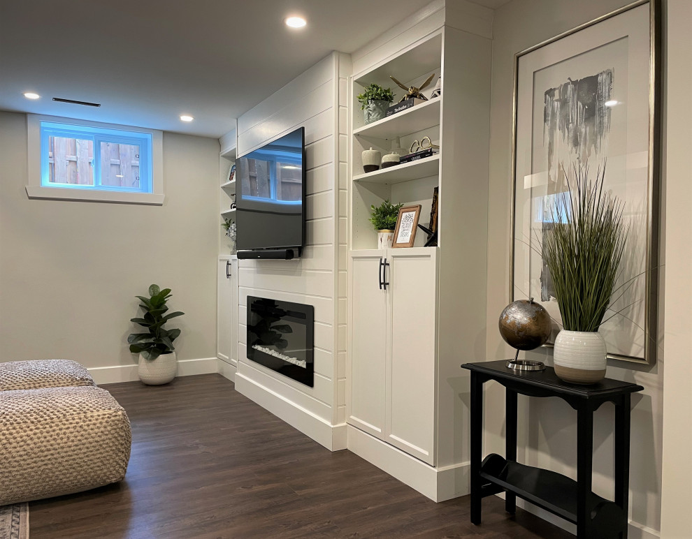 Inspiration for a medium sized traditional look-out basement in Montreal with grey walls, vinyl flooring, a ribbon fireplace, a timber clad chimney breast, brown floors and exposed beams.