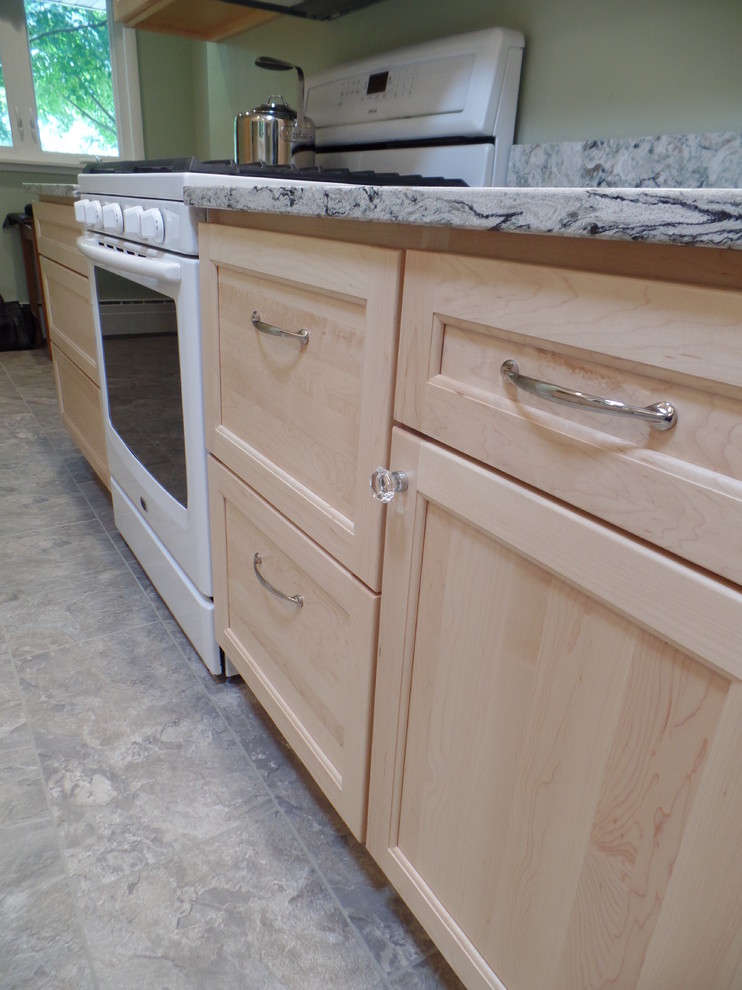 Example of a mid-sized transitional galley vinyl floor eat-in kitchen design in Cedar Rapids with an undermount sink, shaker cabinets, light wood cabinets, quartz countertops, white appliances and no island