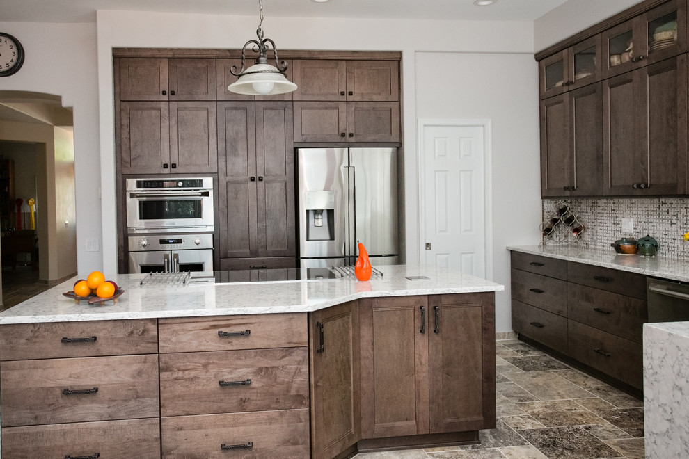 Inspiration for a porcelain tile kitchen remodel in Phoenix with an undermount sink, shaker cabinets, gray cabinets, quartz countertops, white backsplash, ceramic backsplash, stainless steel appliances and an island