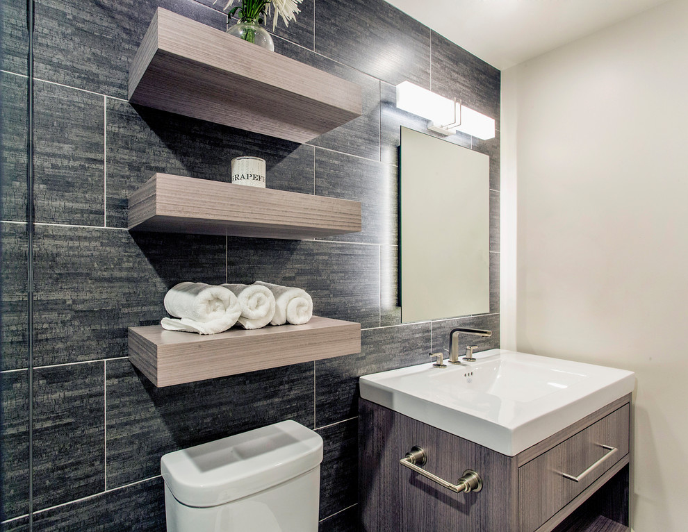 This is an example of a mid-sized contemporary master bathroom in San Diego with flat-panel cabinets, light wood cabinets, a curbless shower, black tile, porcelain tile, pebble tile floors, black floor and an open shower.