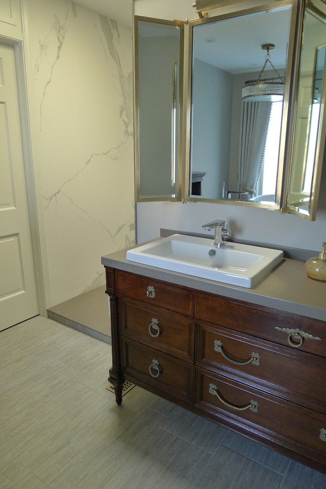 Large transitional master gray tile and porcelain tile porcelain tile freestanding bathtub photo in Indianapolis with a drop-in sink, furniture-like cabinets, dark wood cabinets, solid surface countertops, a one-piece toilet and gray walls