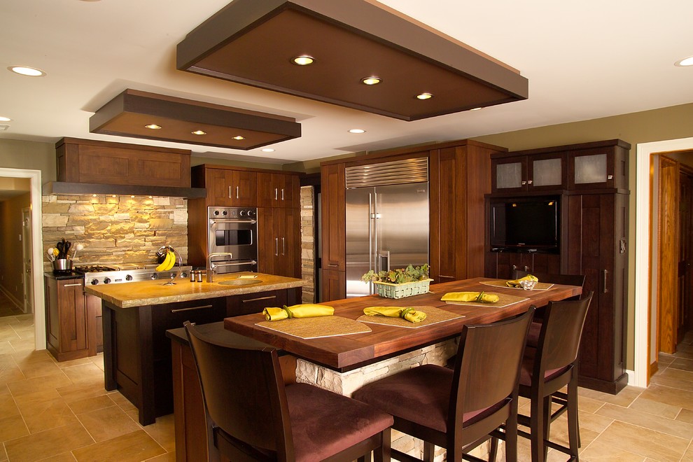 This is an example of a contemporary kitchen in New York with stainless steel appliances and wood benchtops.
