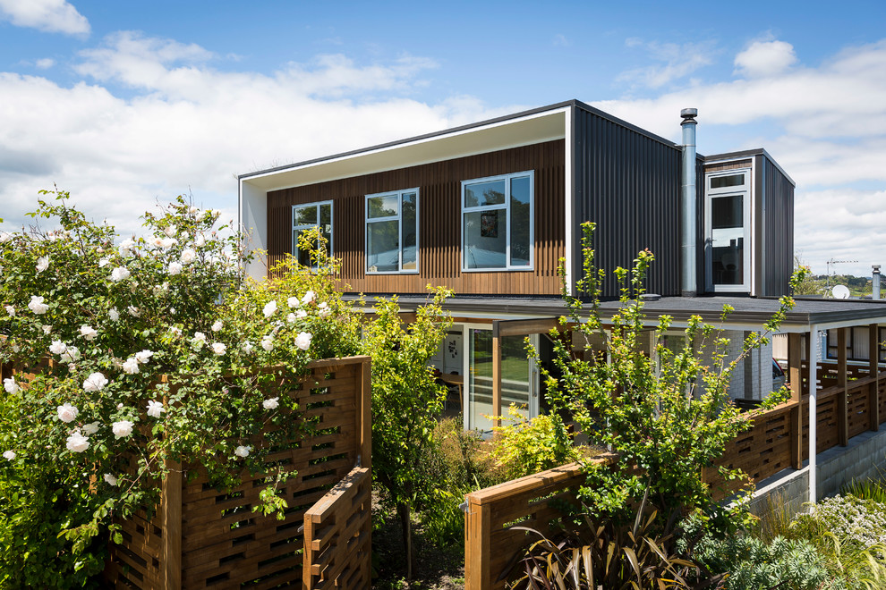 This is an example of a small contemporary two-storey black exterior in Auckland with metal siding and a shed roof.