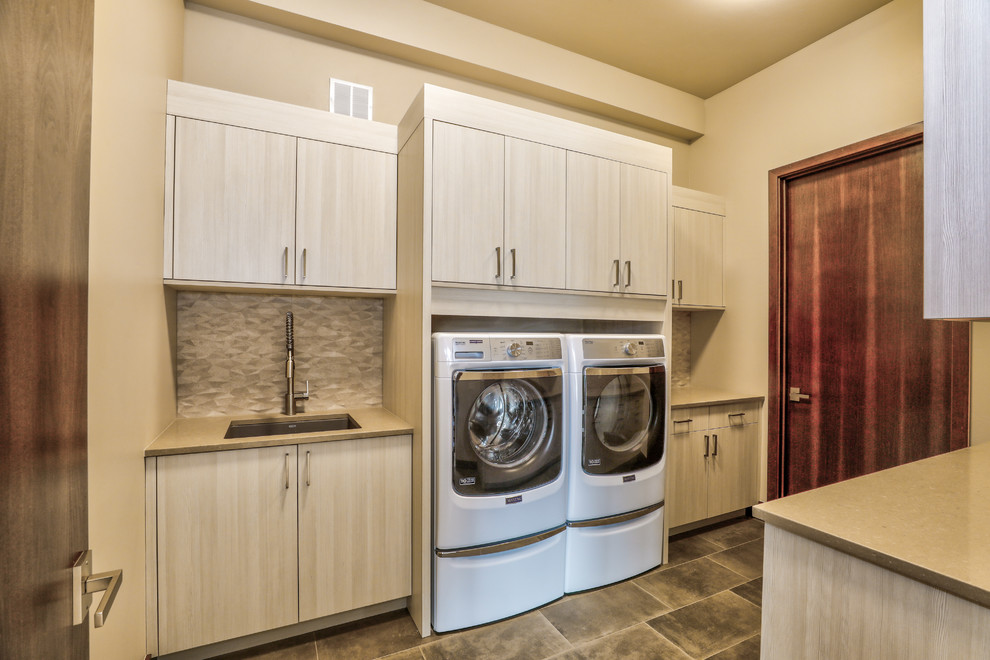 Photo of a mid-sized contemporary dedicated laundry room in Other with an undermount sink, flat-panel cabinets, white cabinets and a side-by-side washer and dryer.