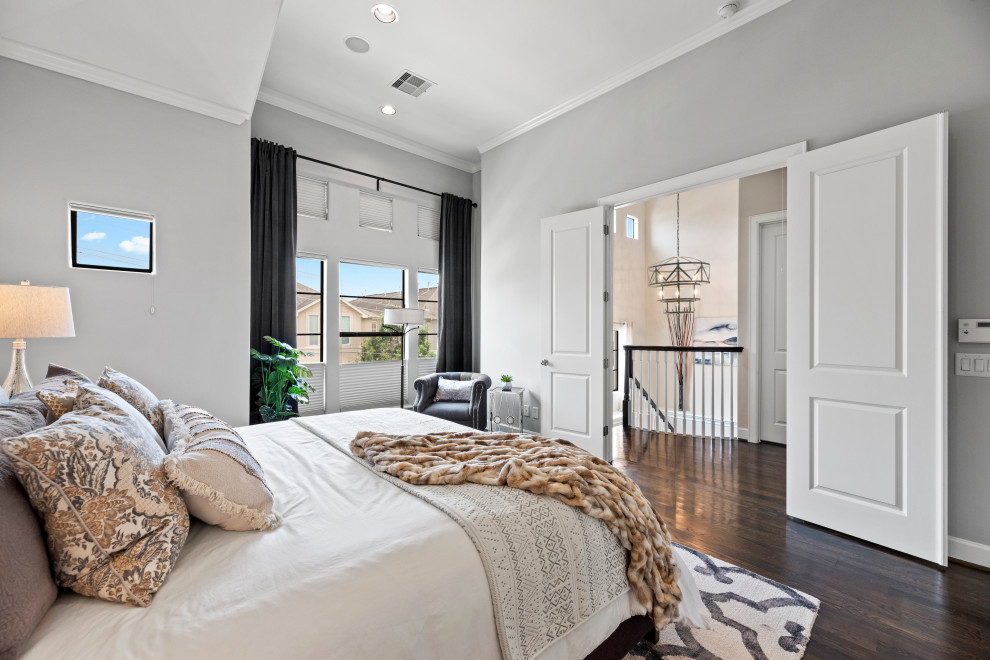 Photo of a large transitional master bedroom in Houston with grey walls and dark hardwood floors.