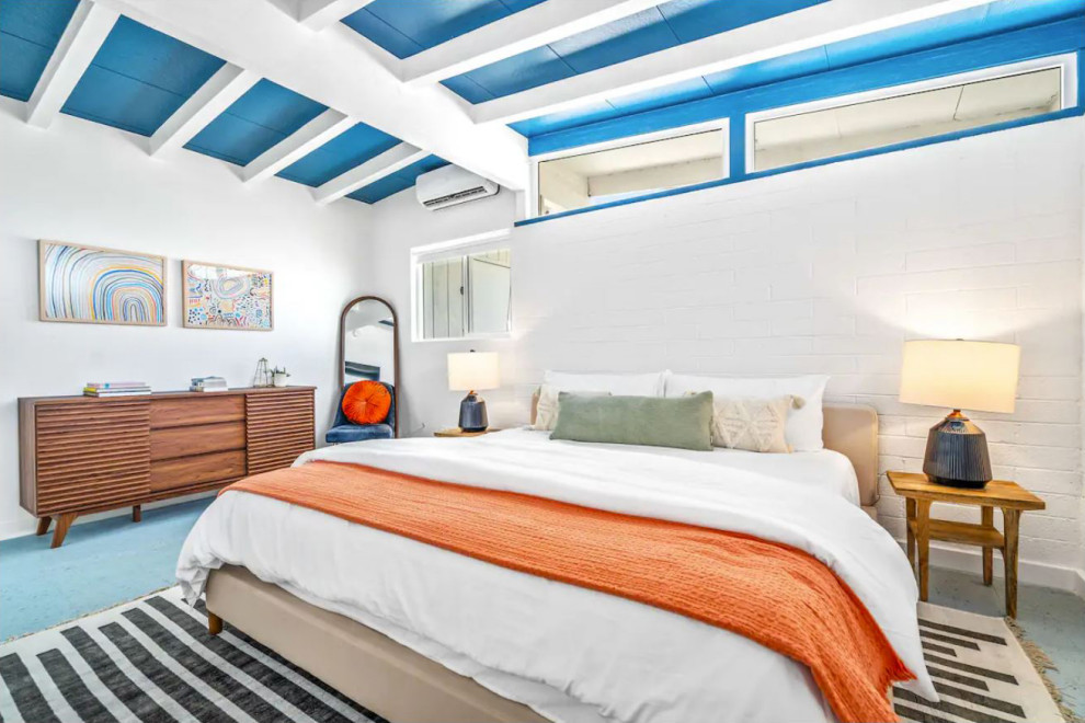 Retro master bedroom in Other with white walls, laminate floors, blue floors, exposed beams and brick walls.