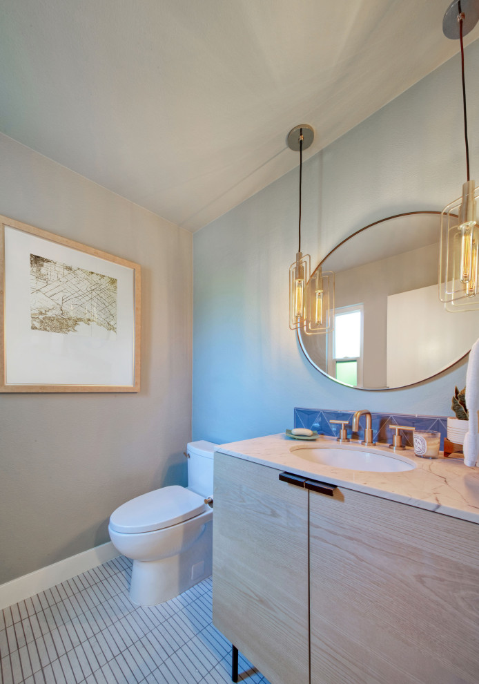 Свежая идея для дизайна: туалет среднего размера в стиле ретро с плоскими фасадами, светлыми деревянными фасадами, унитазом-моноблоком, синей плиткой, керамической плиткой, зелеными стенами, полом из мозаичной плитки, врезной раковиной, столешницей из искусственного кварца, белым полом, белой столешницей и встроенной тумбой - отличное фото интерьера