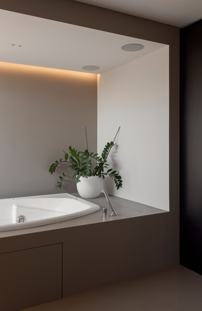 Cette image montre une petite salle de bain design avec un bain bouillonnant, un combiné douche/baignoire, un carrelage vert, un carrelage en pâte de verre, un mur gris, sol en béton ciré, un sol gris, une cabine de douche à porte battante, un plan de toilette gris, une niche, meuble-lavabo encastré et un plafond décaissé.
