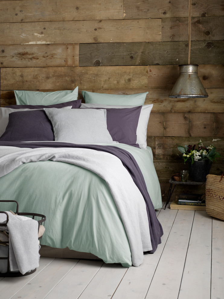 Inspiration for a contemporary bedroom in Sussex with painted wood floors.