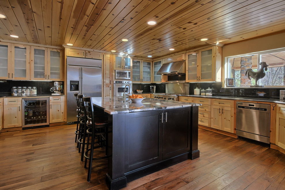 Design ideas for a large country u-shaped eat-in kitchen in Other with an undermount sink, glass-front cabinets, light wood cabinets, stainless steel appliances, medium hardwood floors, with island and black splashback.