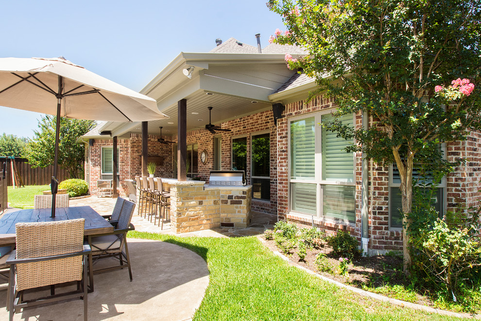 Large country backyard patio in Dallas with an outdoor kitchen, decking and a roof extension.