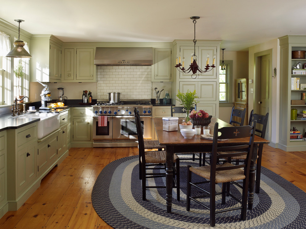 Country l-shaped eat-in kitchen in New York with a farmhouse sink, recessed-panel cabinets and stainless steel appliances.