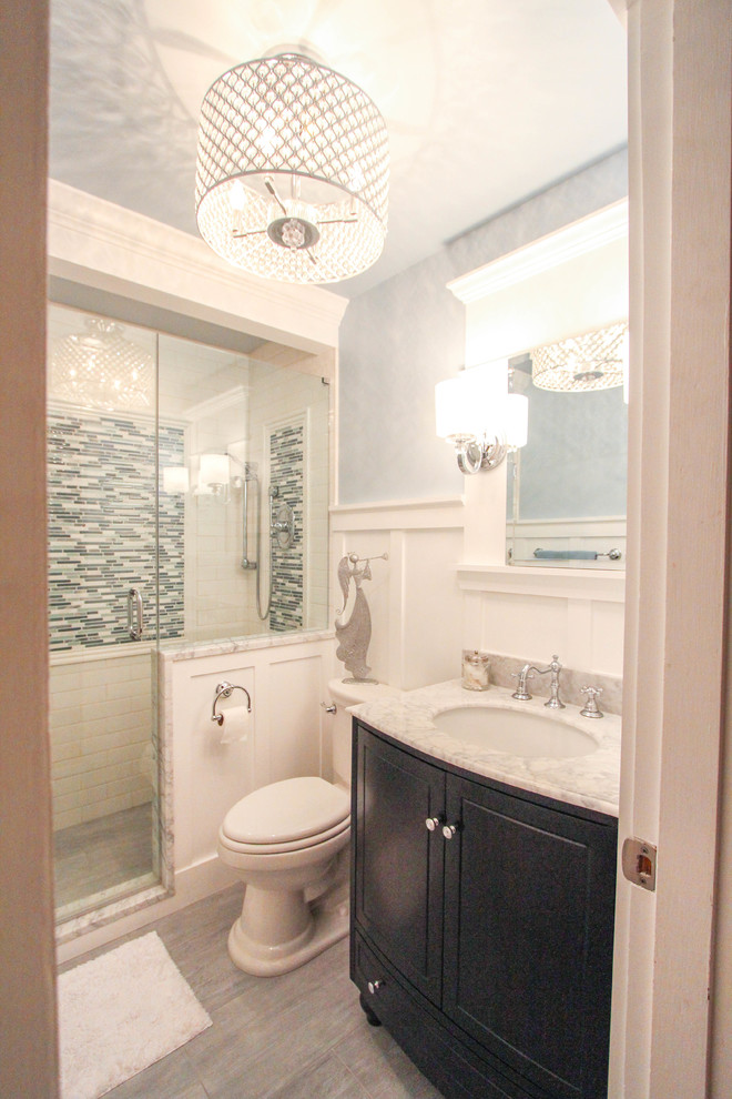 Photo of a small traditional 3/4 bathroom in Cincinnati with an undermount sink, raised-panel cabinets, dark wood cabinets, marble benchtops, a double shower, a two-piece toilet, white tile, subway tile, blue walls and travertine floors.