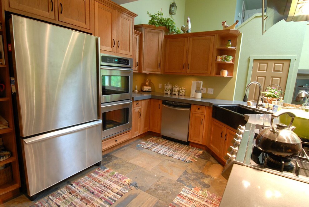 Example of a large transitional l-shaped slate floor and multicolored floor open concept kitchen design with an undermount sink, shaker cabinets, medium tone wood cabinets, quartz countertops, stainless steel appliances, an island and gray countertops