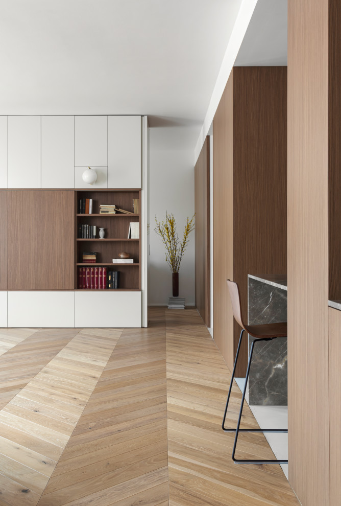 Esempio di un grande soggiorno moderno aperto con pareti bianche, pavimento in legno massello medio e pannellatura
