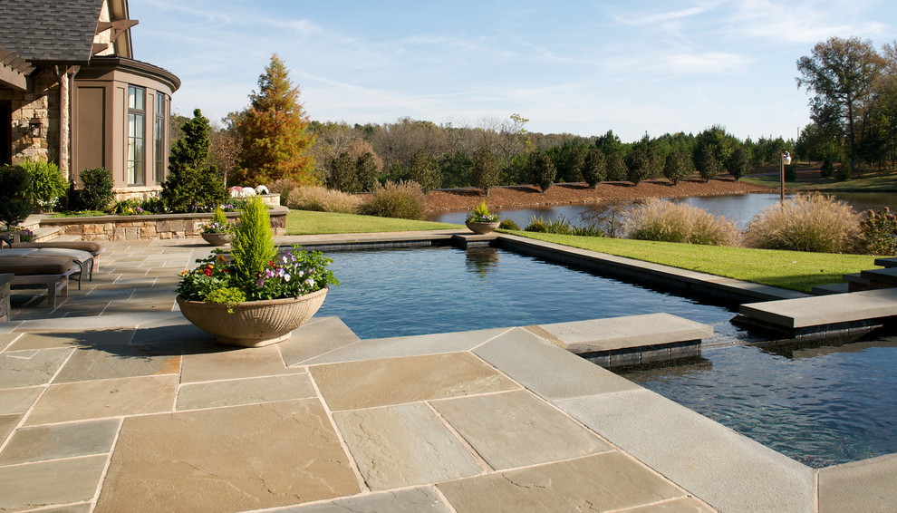 Inspiration for a mid-sized traditional backyard rectangular pool in Atlanta with natural stone pavers and a hot tub.