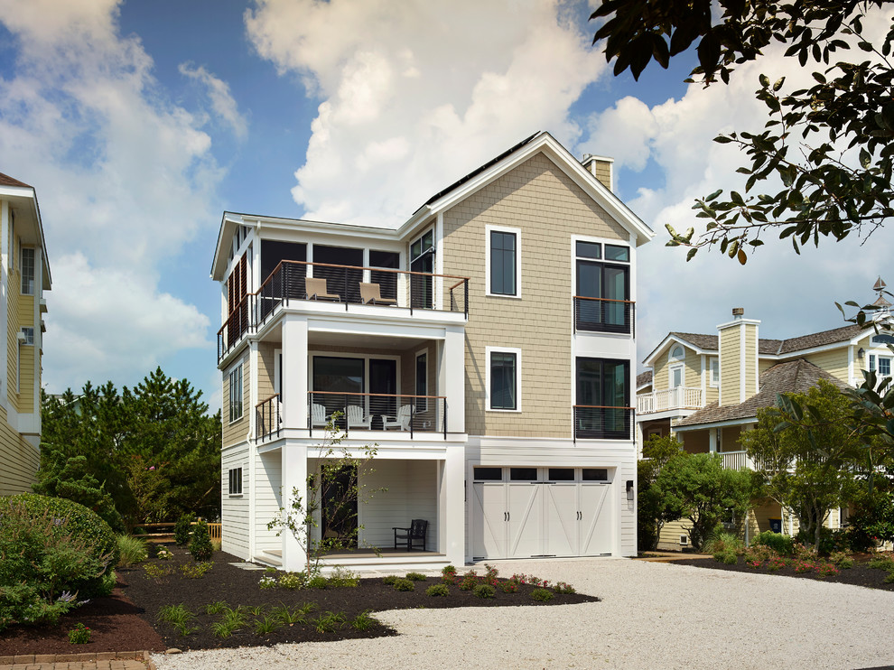 This is an example of a large beach style three-storey beige house exterior in DC Metro with a gable roof, a shingle roof and mixed siding.