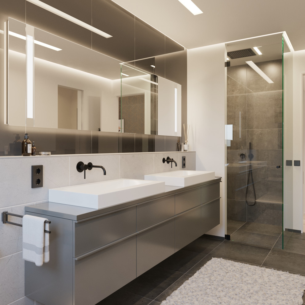 Design ideas for a mid-sized contemporary 3/4 bathroom in Dusseldorf with flat-panel cabinets, grey cabinets, a corner shower, gray tile, porcelain tile, beige walls, porcelain floors, a vessel sink, grey floor, a hinged shower door and grey benchtops.
