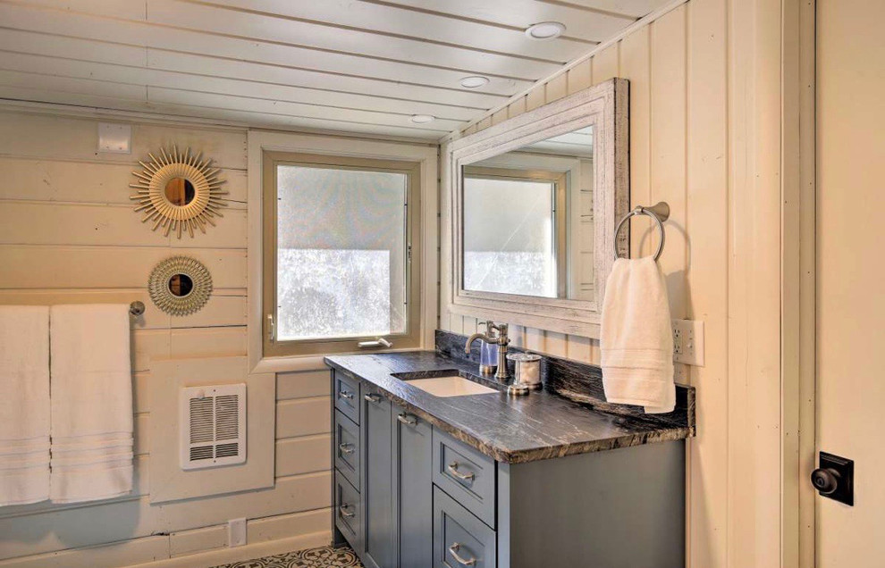 Photo of a mid-sized country bathroom in Other with recessed-panel cabinets, blue cabinets, white walls, ceramic floors, engineered quartz benchtops, black floor and grey benchtops.